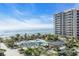 Relaxing pool area with ocean views, lush landscaping, and a high-rise building at 1211 Gulf Of Mexico Dr # 403, Longboat Key, FL 34228