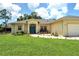 Single-story home with a landscaped lawn and attached garage at 1447 Allegheny Ln, North Port, FL 34286