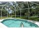 Inviting screened pool with ample deck space and lush landscaping at 1447 Allegheny Ln, North Port, FL 34286