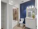 Modern bathroom with blue accent wall, bathtub, and granite vanity at 17607 Gawthrop Dr # 103, Bradenton, FL 34211