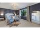 Spacious bedroom with a large window, two armchairs and a chandelier at 17607 Gawthrop Dr # 103, Bradenton, FL 34211