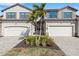 Two-story townhome with attached two-car garage, landscaped front yard, and paver driveway at 17607 Gawthrop Dr # 103, Bradenton, FL 34211