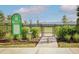 Dog park entrance with green sign and small dog at 17920 Palmiste Dr, Bradenton, FL 34202
