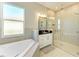 Spa-like bathroom featuring a corner tub, glass shower, and updated fixtures at 1810 5Th E St, Palmetto, FL 34221