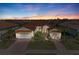 Two-story house with tile roof, two-car garage, and landscaped yard at sunset at 1810 5Th E St, Palmetto, FL 34221