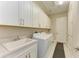 Bright laundry room with white cabinets, quartz countertops, and modern washer/dryer at 1810 5Th E St, Palmetto, FL 34221
