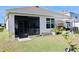 Screened patio with backyard access, lush landscaping, and a shaded seating area at 2111 Tally Breeze Way, Bradenton, FL 34208