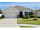 Tan house with a two-car garage and landscaped yard at 2111 Tally Breeze Way, Bradenton, FL 34208