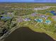 Aerial view of community amenities including pools, tennis courts, and a lake at 21620 Avon Park Ct, Venice, FL 34293