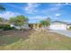 Ranch-style home with a yellow door, white garage, and landscaped yard at 2708 Bigelow Dr, Sarasota, FL 34239