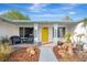 Inviting front porch with yellow door, brick walkway, and potted plants at 2708 Bigelow Dr, Sarasota, FL 34239