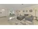 Spacious living room with grey sectional sofa and large windows at 2708 Bigelow Dr, Sarasota, FL 34239