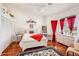 Bright bedroom with white furniture, red accents, and hardwood floors at 3011 Ashton Rd, Sarasota, FL 34231