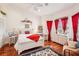 Bright bedroom with white furniture, red accents, and hardwood floors at 3011 Ashton Rd, Sarasota, FL 34231