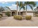 Single story home with a circular driveway, palm trees, and light colored walls at 3011 Ashton Rd, Sarasota, FL 34231