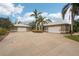 Exterior view of a single-Gathering home with a spacious driveway and palm trees at 3011 Ashton Rd, Sarasota, FL 34231