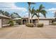 Front view of a single-Gathering house with circular driveway, landscaping, and palm trees at 3011 Ashton Rd, Sarasota, FL 34231