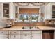 Kitchen with double sink, white cabinets, and window above at 3011 Ashton Rd, Sarasota, FL 34231