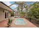 Enclosed pool and spa area with brick patio and lush landscaping at 3011 Ashton Rd, Sarasota, FL 34231