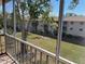 View of community grounds with lush landscaping and trees from screened balcony at 3983 Maceachen Blvd # 432, Sarasota, FL 34233