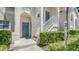Condo building entrance with teal door and manicured hedges at 4275 Castlebridge Ln # 1312B1, Sarasota, FL 34238