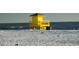 Yellow lifeguard stand on a sandy beach with ocean waves at 4275 Castlebridge Ln # 1312B1, Sarasota, FL 34238