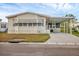 Tan single-wide manufactured home with carport and landscaped lawn at 4316 12Th Street E Ct, Ellenton, FL 34222