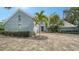 Gray brick house with palm trees and a paver driveway at 4892 Peregrine E Pt, Sarasota, FL 34231