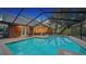 Enclosed pool and patio area with brick pavers and screened-in enclosure at 4892 Peregrine E Pt, Sarasota, FL 34231