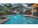 Expansive screened pool at dusk with LED lighting at 4892 Peregrine E Pt, Sarasota, FL 34231