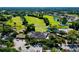 Aerial view showing clubhouse, parking, and green golf course at 5152 Marsh Field Ln # 117, Sarasota, FL 34235