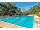 Refreshing community pool with multiple lap lanes and surrounding trees at 5152 Marsh Field Ln # 117, Sarasota, FL 34235