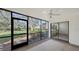 Bright screened porch with view of lush landscaping and sliding glass door to interior at 5152 Marsh Field Ln # 117, Sarasota, FL 34235