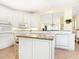 Spacious kitchen boasts white cabinetry, granite countertops, and island with seating at 5440 Eagles Point Cir # 405, Sarasota, FL 34231
