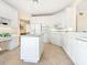 White kitchen with granite island, ample cabinetry, and breakfast bar at 5440 Eagles Point Cir # 405, Sarasota, FL 34231