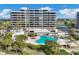 Aerial view of resort with pool, landscaping, and tennis courts at 545 Sanctuary Dr # A803, Longboat Key, FL 34228