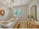 Dining room features light walls, wood floors, and a statement chandelier at 5554 New Covington Dr, Sarasota, FL 34233