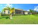 Landscaped backyard with lush lawn and screened patio at 6337 Rivo Lakes Blvd, Sarasota, FL 34241