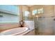 Relaxing bathroom with soaking tub, walk-in shower, and natural light at 6337 Rivo Lakes Blvd, Sarasota, FL 34241
