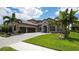 Luxury home with stone accents, three-car garage, and lush landscaping at 6337 Rivo Lakes Blvd, Sarasota, FL 34241