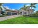 Beautiful two-story home with three-car garage and lush landscaping at 6337 Rivo Lakes Blvd, Sarasota, FL 34241