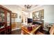 Bright home office with hardwood floors, custom desk, and view to the dining room at 6337 Rivo Lakes Blvd, Sarasota, FL 34241