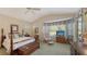 Main bedroom with a wood post bed, ample natural light and a view to the backyard at 7121 Victoria Cir, University Park, FL 34201