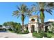 Gated community entrance with palm trees and a beautiful building at 7160 Rue De Palisades # 4, Sarasota, FL 34238