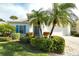 Landscaped front yard with palm trees and a white house with blue shutters at 7160 Rue De Palisades # 4, Sarasota, FL 34238