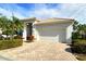 Front view of a one-story house with a white exterior and a large garage at 7160 Rue De Palisades # 4, Sarasota, FL 34238