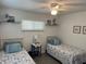 Guest bedroom with twin beds, nightstands, and coastal decor at 935 Rhodes Ave, Sarasota, FL 34237