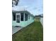 Side view of the house showcasing the light green exterior and screened porch at 935 Rhodes Ave, Sarasota, FL 34237