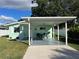 Charming light green house with carport and well-maintained landscaping at 935 Rhodes Ave, Sarasota, FL 34237
