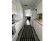 Clean kitchen with white cabinets, granite counters, and view of living area at 935 Rhodes Ave, Sarasota, FL 34237